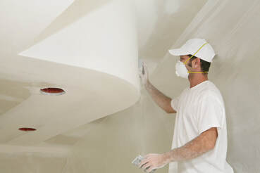 Painter sanding ceiling and build outs for paint preparation
